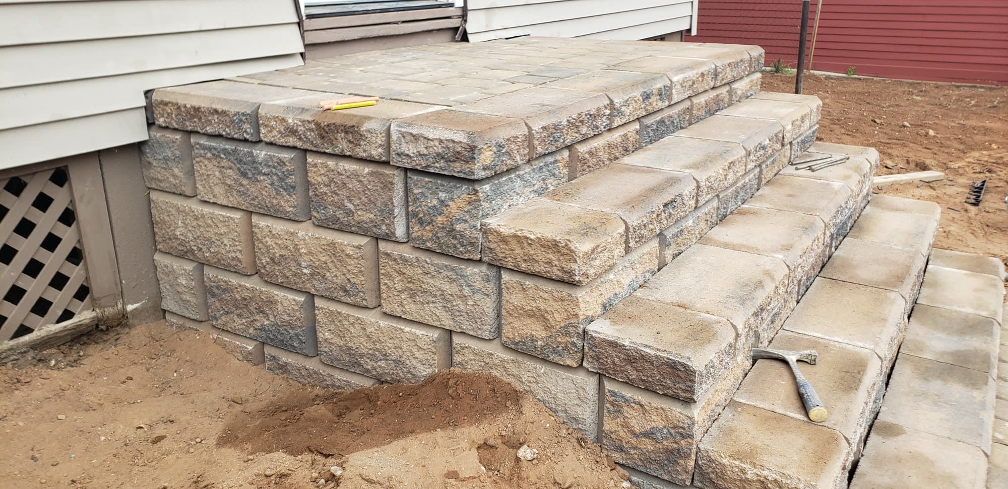 Block stoop and steps under construction beside a house, showing the block structure